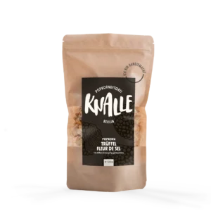 Das Bild zeigt eine Popkorn Verpackung - wiederverschließbare braune Tüte. Das Etikett ist schwarz mit weißer Schrift