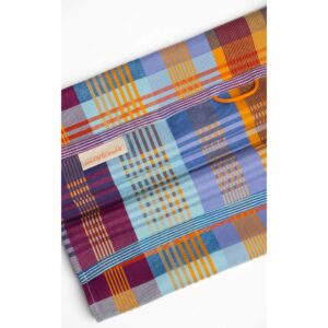 Geschirrtuch - wild weave #95A 11 Bunt kariertes Geschirrtuch mit großflächigem Patchwork-Muster in Blau-, Rot-, Gelb-, Orange- und Lilatönen, mit orangefarbener Aufhängeschlaufe oben mittig und schmalen, gestreiften Abschlusskanten.